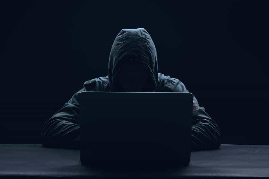 Hooded hacker at computer
