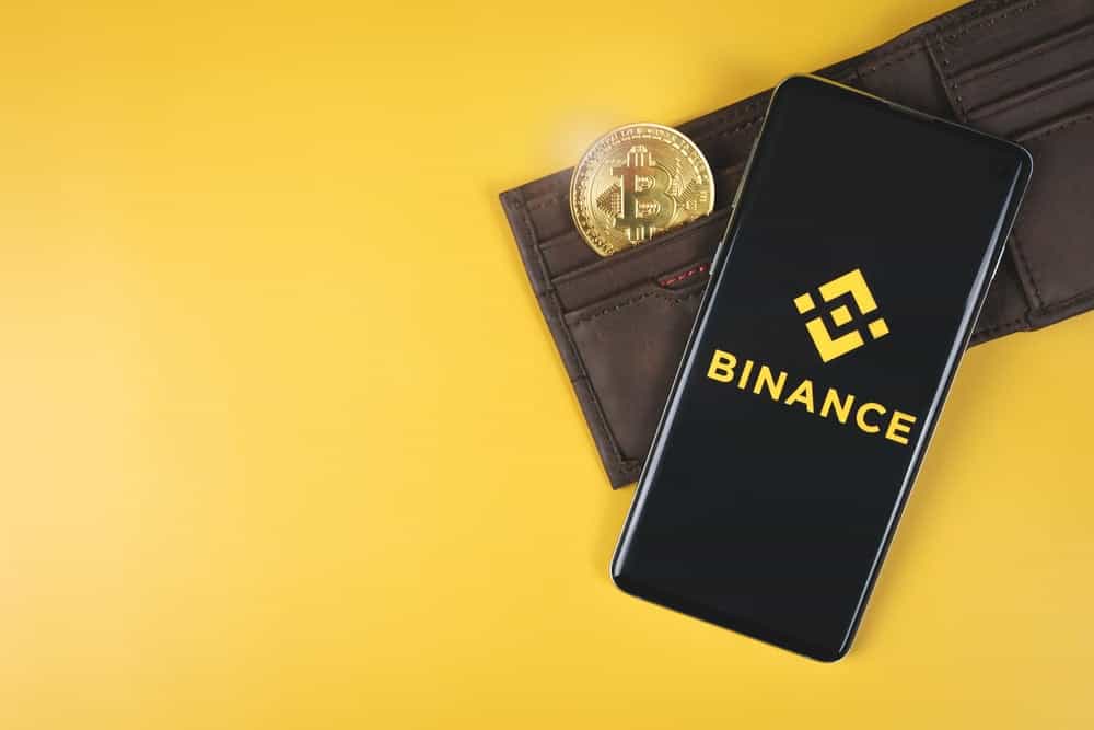 Binance,Mobile,App,Logo,On,A,Smartphone,,Wallet,With,Gold